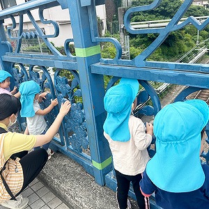 お散歩の途中で電車をみつめる子どもたち