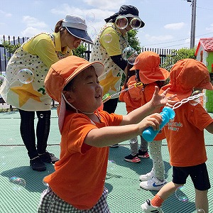 夢中でシャボン玉で遊ぶ子どもたち