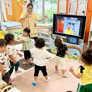 画面に映る先生と一緒に歌をうたい踊る子どもたち