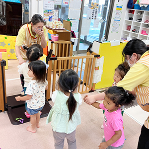 手を口に当てて避難訓練をする子どもたちと先生