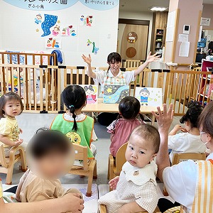 七夕の紙芝居を見入る子どもとカメラが気になって振り向く子どもたち