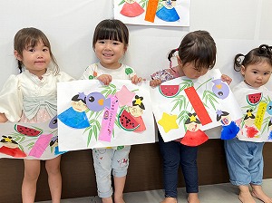 七夕の作品を手に持ち微笑む子どもたち