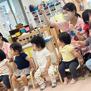 椅子に座って先生の方を見つめる子どもたち