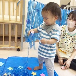 スズランテープの天の川から星をみつける子ども