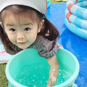 バケツに中の水に手を浸ける子ども