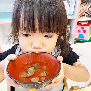 お吸い物を飲む子ども