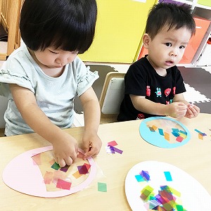 真剣な表情でカラーセロハンを貼る子どもたち