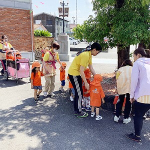 屋外の広い場所に避難する保育士と子どもたち