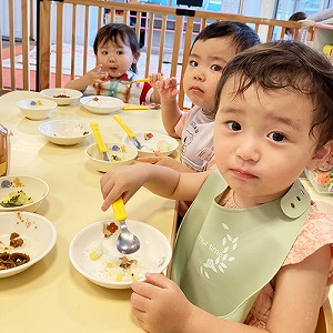 スプーンを握り給食を食べる子どもたち