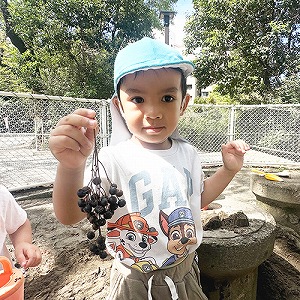 木の実をみせる子ども