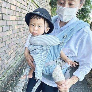 保育士に抱っこされお散歩にでかける子ども