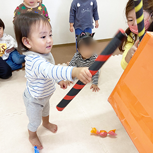 ピニャータを棒で叩く子ども