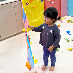 カーテンについたキャンディなどを取る子ども