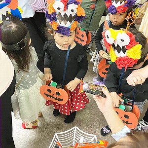 ハロウィーンの仮装をしてお菓子をもらう子どもたち