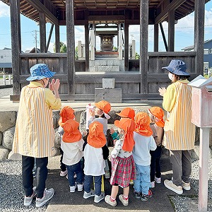 神社でお参りをする保育士と子どもたち