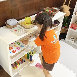 棚に教具を片付ける子ども