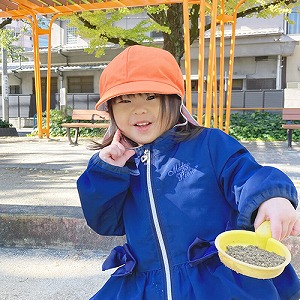 砂場でポーズをとる子ども