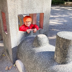 汽車の形のオブジェに入って笑顔を見せる子ども