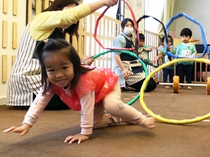 輪くぐりをして笑顔を見せる子ども