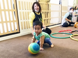 サッカーをする子どもと見守る保育士